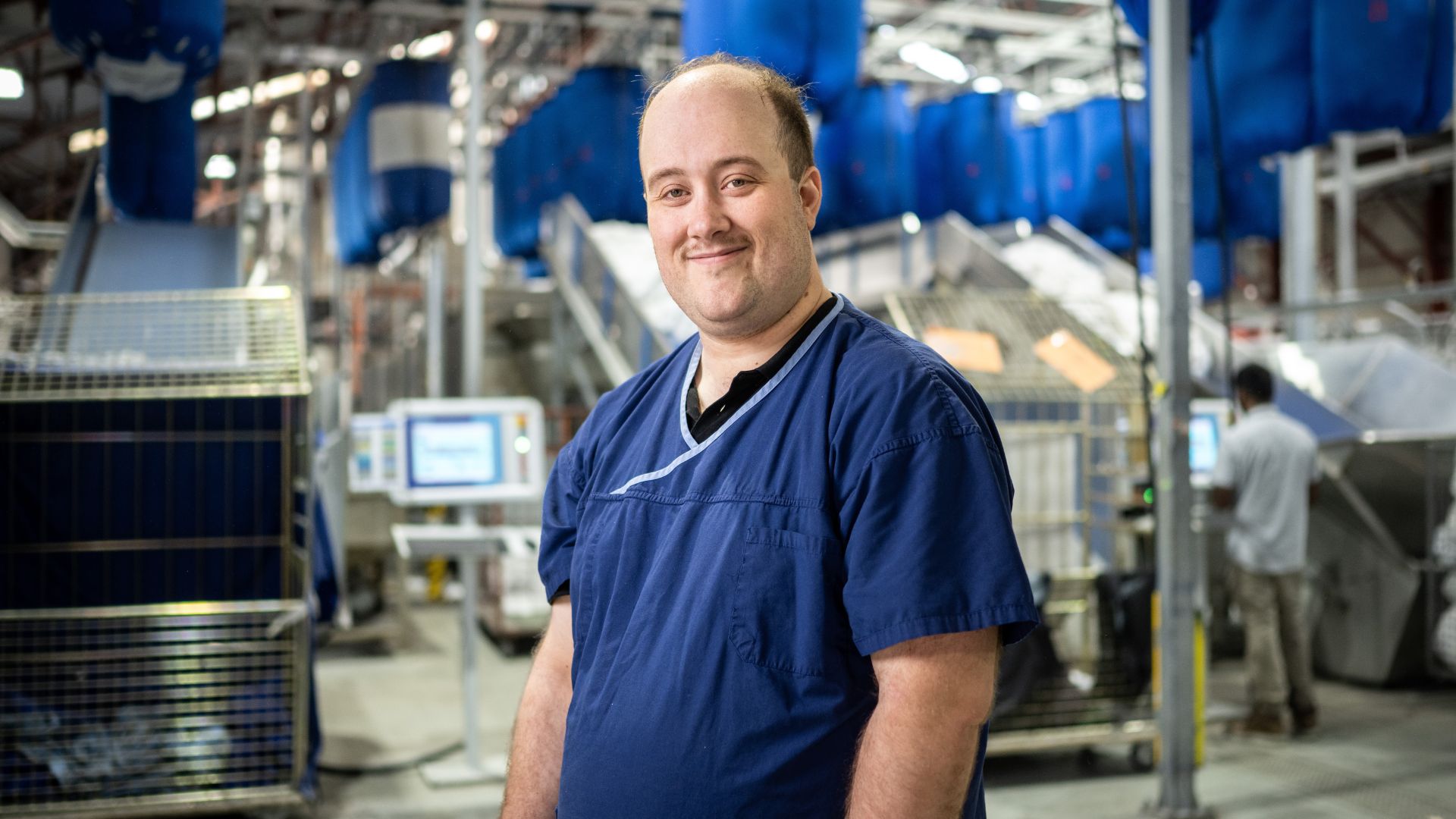 DES participant Stephen smiles as he works in a warehouse